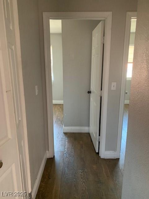 corridor featuring wood finished floors and baseboards