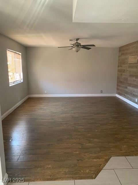 spare room with wood-type flooring, ceiling fan, and baseboards