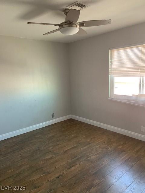 spare room featuring dark wood finished floors, baseboards, and ceiling fan