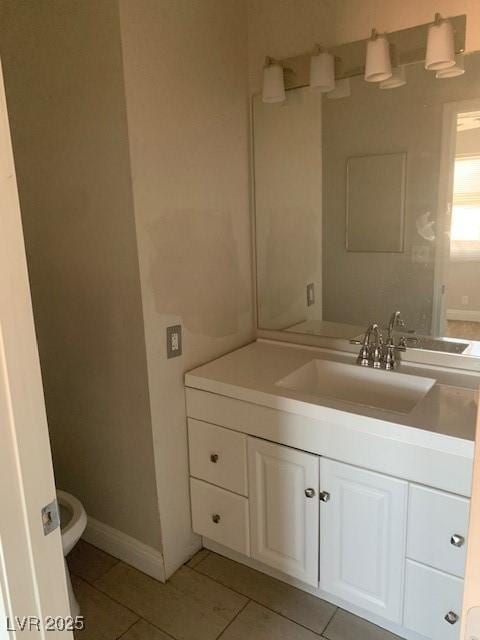 half bath with tile patterned flooring, vanity, toilet, and baseboards