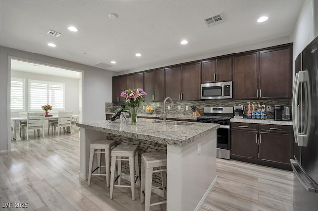205 Piedmont Alps St, Henderson, NV 89012 - kitchen featuring appliances with stainless steel finishes, a sink, recessed lighting, tasteful backsplash, and light wood-type flooring