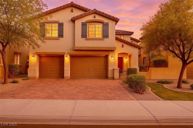 205 Piedmont Alps St, Henderson, NV 89012 - mediterranean / spanish-style house featuring an attached garage, a tiled roof, decorative driveway, and stucco siding