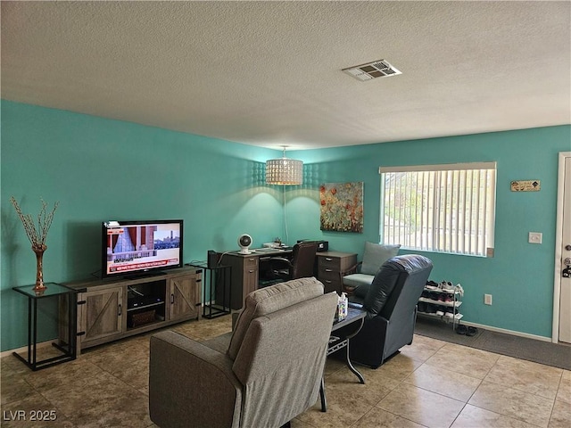 tiled living room with an office area, a textured ceiling, and baseboards