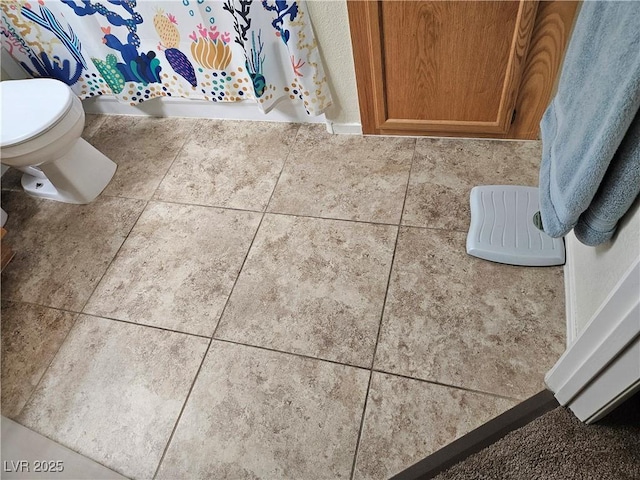 bathroom featuring toilet and tile patterned flooring