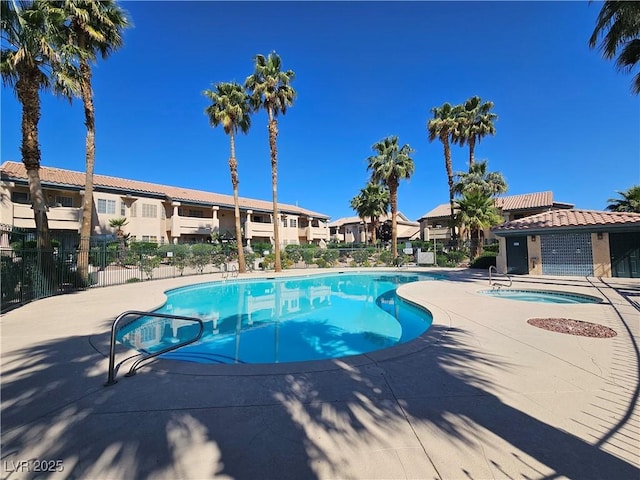 community pool with fence, a residential view, and a patio