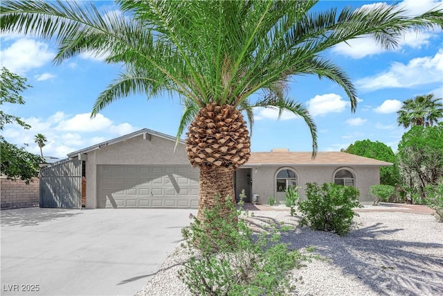 ranch-style house with stucco siding, driveway, and a garage