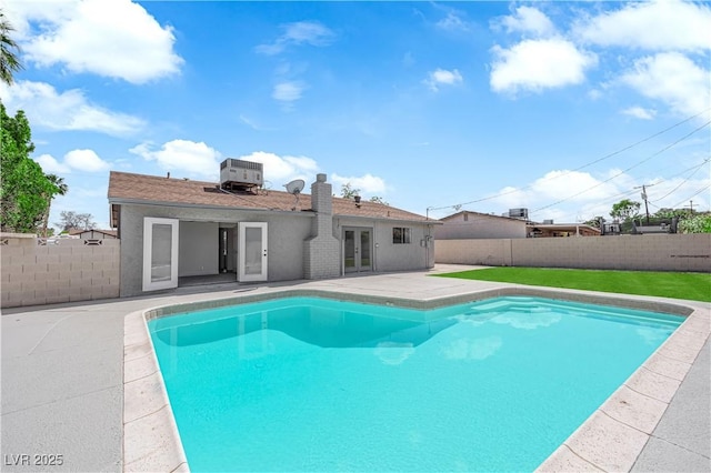 view of swimming pool with french doors, a fenced backyard, a patio, and cooling unit