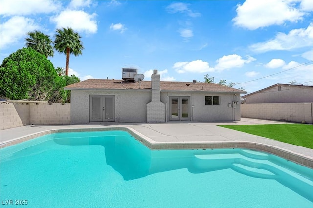 view of pool featuring french doors, a patio area, a fenced backyard, and central AC