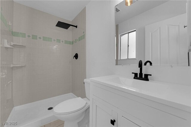 full bathroom featuring toilet, tiled shower, and vanity