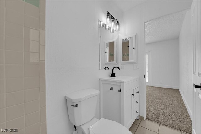 bathroom featuring tile patterned flooring, a textured ceiling, toilet, and vanity