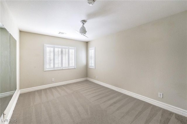 empty room with carpet, baseboards, and a smoke detector