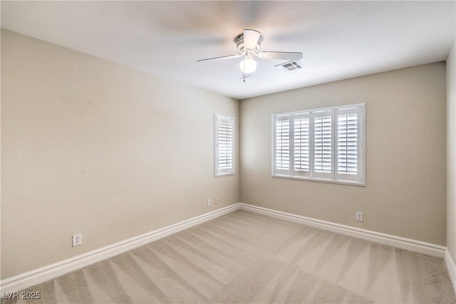 empty room with carpet flooring, a ceiling fan, and baseboards