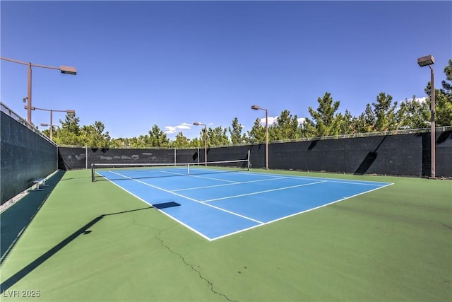 view of tennis court with fence and community basketball court