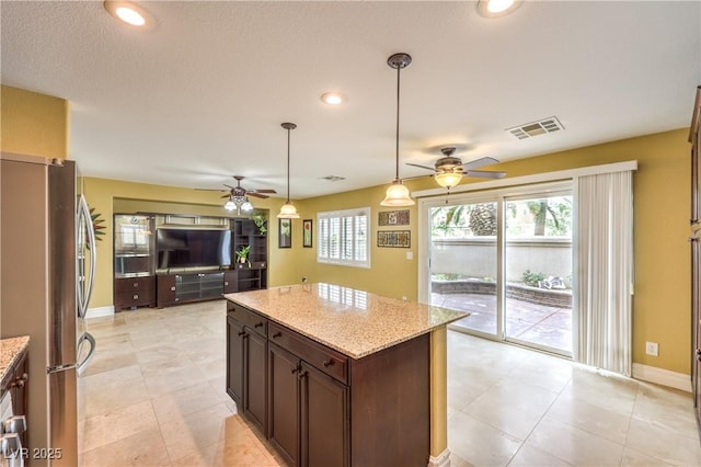 kitchen featuring freestanding refrigerator, ceiling fan, light stone countertops, and recessed lighting