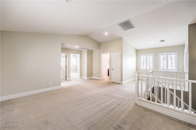 spare room featuring light carpet, baseboards, lofted ceiling, and recessed lighting