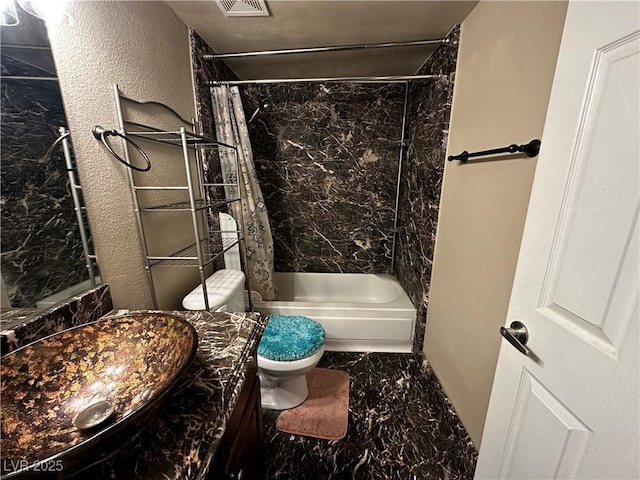 bathroom featuring marble finish floors, toilet, shower / tub combo, and vanity