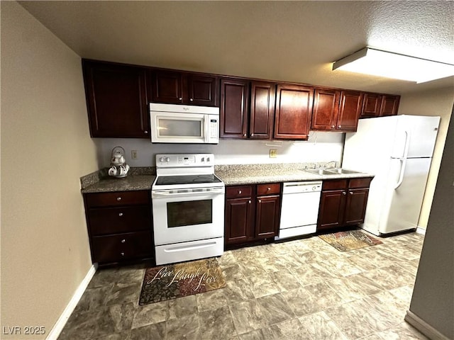 kitchen with white appliances, baseboards, and a sink