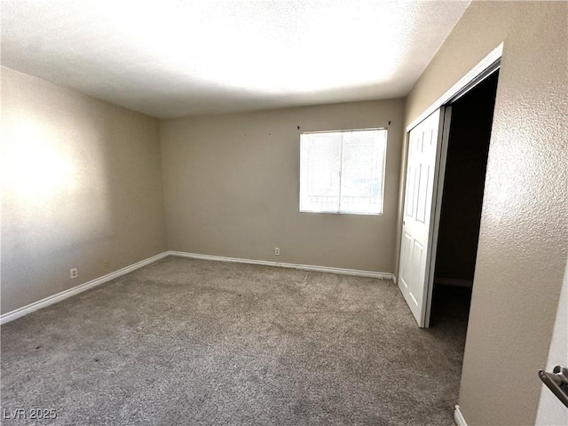 unfurnished bedroom featuring carpet, baseboards, and a closet