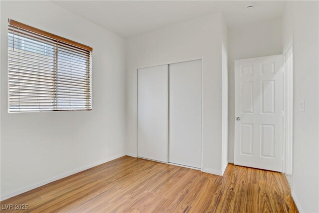 11247 Villa Trentino Ct, Las Vegas, NV 89141 - unfurnished bedroom with light wood-style flooring, a closet, and baseboards