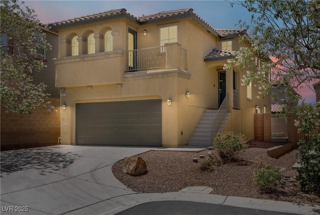 11247 Villa Trentino Ct, Las Vegas, NV 89141 - mediterranean / spanish home featuring a balcony, a tile roof, stucco siding, concrete driveway, and an attached garage