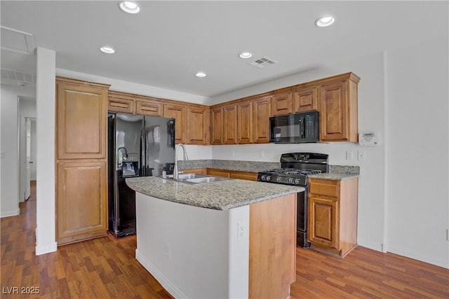 11247 Villa Trentino Ct, Las Vegas, NV 89141 - kitchen with black appliances, a sink, wood finished floors, light stone counters, and recessed lighting