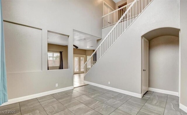971 Whispering Grove Ave, Las Vegas, NV 89123 - tiled entryway featuring stairs, a towering ceiling, baseboards, and arched walkways
