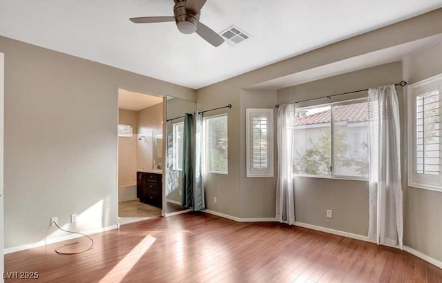 971 Whispering Grove Ave, Las Vegas, NV 89123 - unfurnished bedroom with hardwood / wood-style flooring, baseboards, connected bathroom, and a ceiling fan