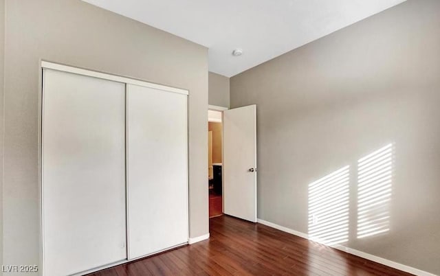 971 Whispering Grove Ave, Las Vegas, NV 89123 - unfurnished bedroom with wood finished floors, a closet, and baseboards