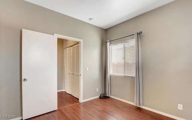 971 Whispering Grove Ave, Las Vegas, NV 89123 - unfurnished bedroom featuring wood finished floors, baseboards, and a closet