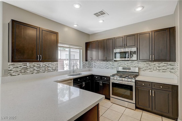 971 Whispering Grove Ave, Las Vegas, NV 89123 - kitchen featuring stainless steel appliances, dark brown cabinets, light tile patterned flooring, backsplash, and recessed lighting