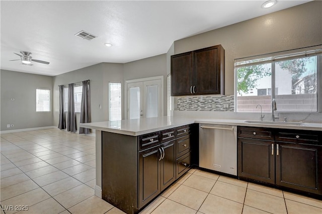 971 Whispering Grove Ave, Las Vegas, NV 89123 - kitchen with dishwasher, light countertops, light tile patterned floors, a peninsula, and plenty of natural light