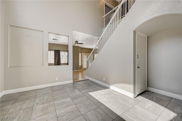 971 Whispering Grove Ave, Las Vegas, NV 89123 - unfurnished room featuring stairway, a ceiling fan, arched walkways, and a high ceiling