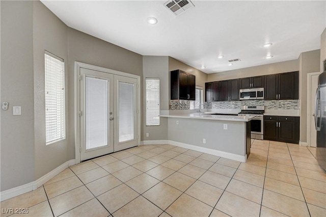 971 Whispering Grove Ave, Las Vegas, NV 89123 - kitchen featuring stainless steel appliances, french doors, light tile patterned flooring, decorative backsplash, and recessed lighting