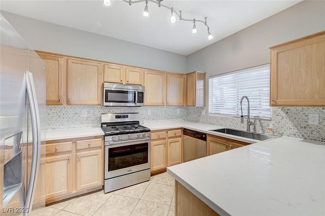 kitchen with appliances with stainless steel finishes, light brown cabinets, a sink, backsplash, and light tile patterned flooring