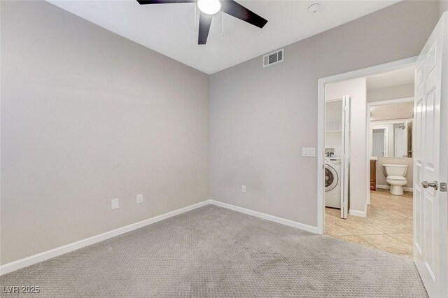 spare room featuring washer / clothes dryer, ceiling fan, baseboards, and carpet floors