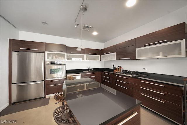900 Las Vegas Blvd Unit 715, Las Vegas, NV 89101 - kitchen with stainless steel appliances, modern cabinets, dark countertops, dark brown cabinetry, and pendant lighting