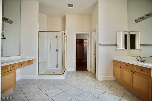 66 Sunset Bay St, Las Vegas, NV 89148 - full bathroom with a stall shower, tile patterned floors, vanity, a walk in closet, and baseboards