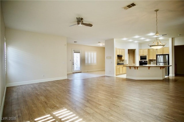 66 Sunset Bay St, Las Vegas, NV 89148 - unfurnished living room with light wood-style flooring, a ceiling fan, baseboards, and a sink