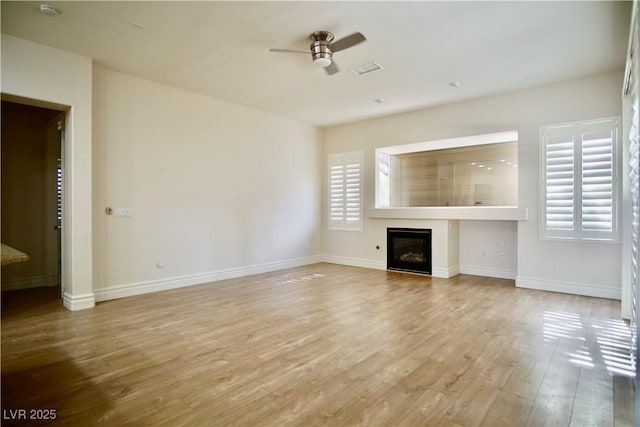 66 Sunset Bay St, Las Vegas, NV 89148 - unfurnished living room with a ceiling fan, wood finished floors, a glass covered fireplace, and baseboards