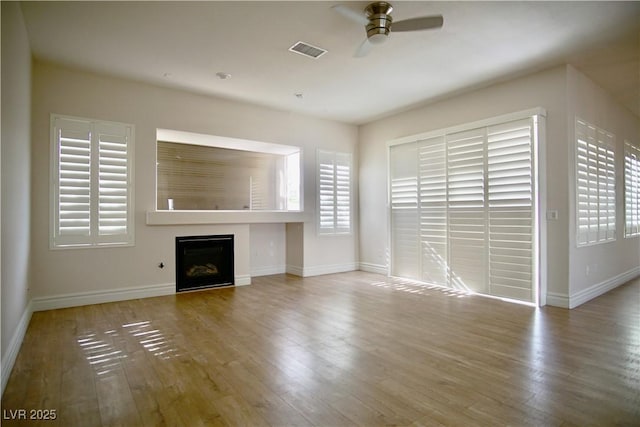 66 Sunset Bay St, Las Vegas, NV 89148 - unfurnished living room featuring a ceiling fan, a fireplace, wood finished floors, and baseboards
