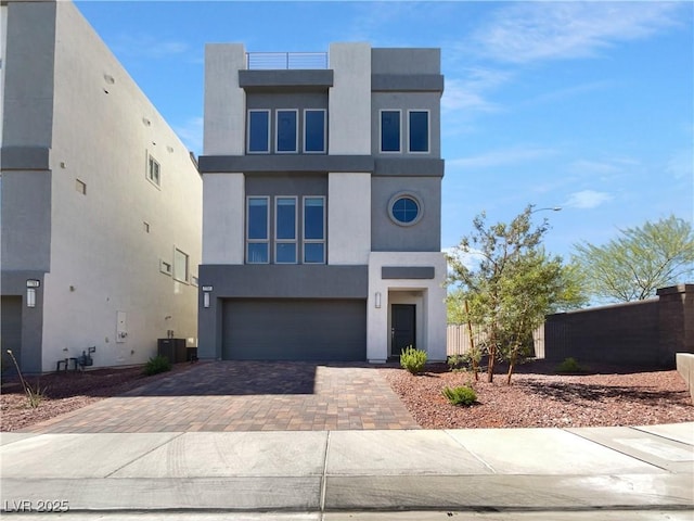 7791 Misty Oaks Ave, Las Vegas, NV 89113 - contemporary home featuring decorative driveway, central AC, an attached garage, stucco siding, and fence