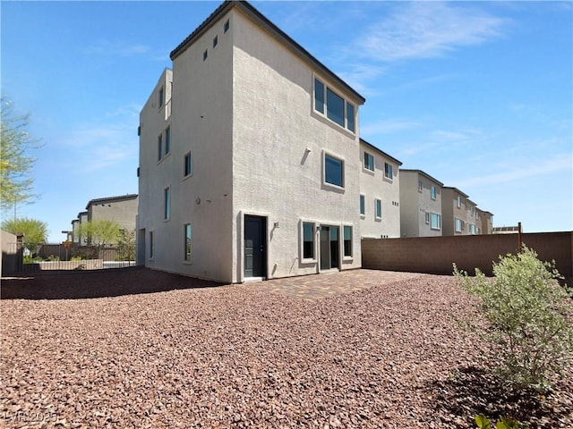 7791 Misty Oaks Ave, Las Vegas, NV 89113 - back of property with fence, a patio area, stucco siding, and a residential view