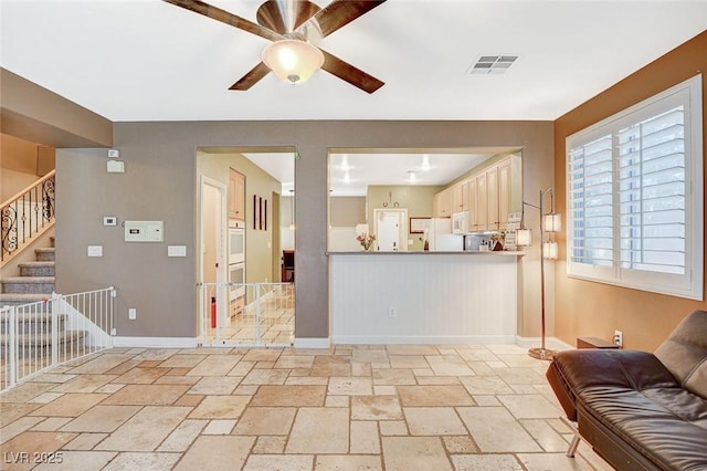 6409 Sea Swallow St, North Las Vegas, NV 89084 - living room with stone tile flooring, ceiling fan, baseboards, and stairway