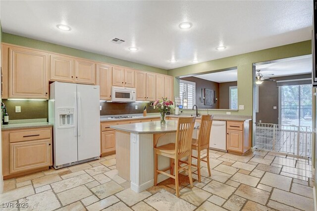 6409 Sea Swallow St, North Las Vegas, NV 89084 - kitchen featuring white appliances, light brown cabinetry, light countertops, healthy amount of natural light, and recessed lighting