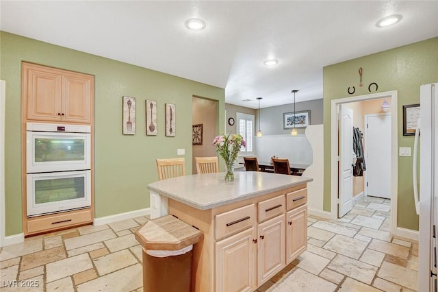 6409 Sea Swallow St, North Las Vegas, NV 89084 - kitchen featuring white appliances, stone tile floors, light countertops, recessed lighting, and a center island