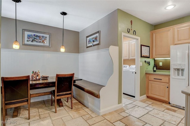 6409 Sea Swallow St, North Las Vegas, NV 89084 - dining space with washer and dryer, stone tile flooring, a wainscoted wall, and baseboards