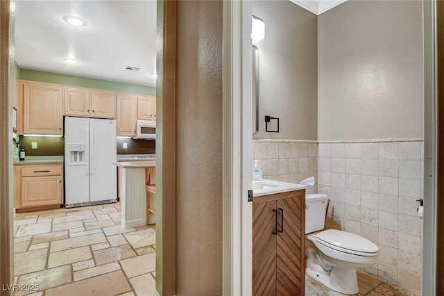 6409 Sea Swallow St, North Las Vegas, NV 89084 - bathroom with toilet, stone tile flooring, vanity, crown molding, and tile walls