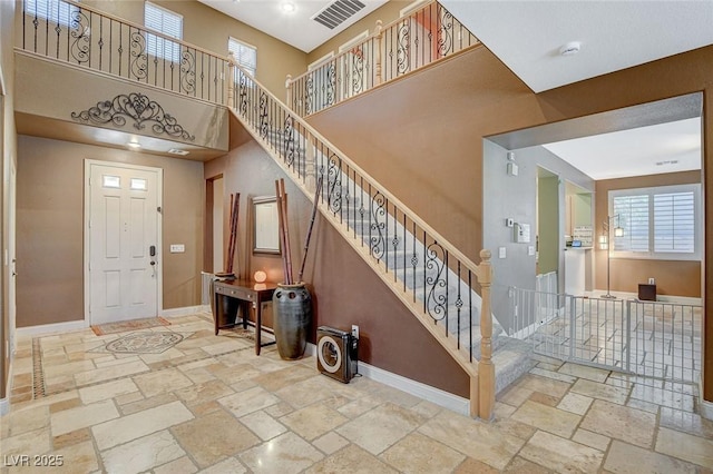6409 Sea Swallow St, North Las Vegas, NV 89084 - foyer featuring stone tile floors, baseboards, a high ceiling, and stairs
