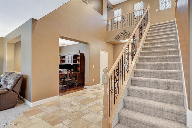 6409 Sea Swallow St, North Las Vegas, NV 89084 - staircase featuring stone tile flooring, baseboards, and a high ceiling