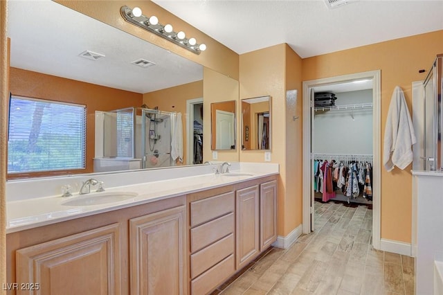 6409 Sea Swallow St, North Las Vegas, NV 89084 - bathroom with a shower stall, a walk in closet, double vanity, and baseboards
